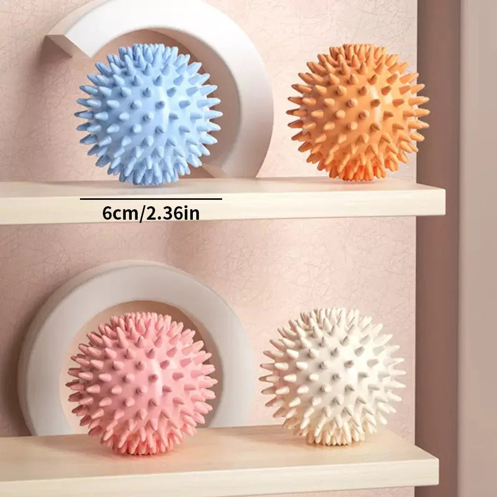Balle de massage PuraDorse Point, 6 cm de diamètre, présentée dans ses quatre coloris sur des étagères claires
