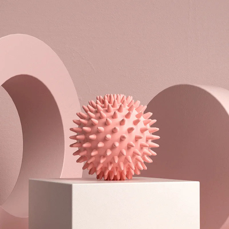 Balle de massage myofasciale PuraDorse Point rose posée sur un socle, fond rosé