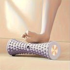 Pied nu roulant sur le rouleau de massage plantaire PuraDorse Roll violet clair