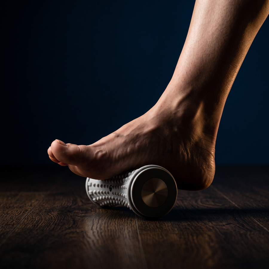Pied nu roulant sur le rouleau de massage plantaire Oléa Roll, assis, lumière rasante